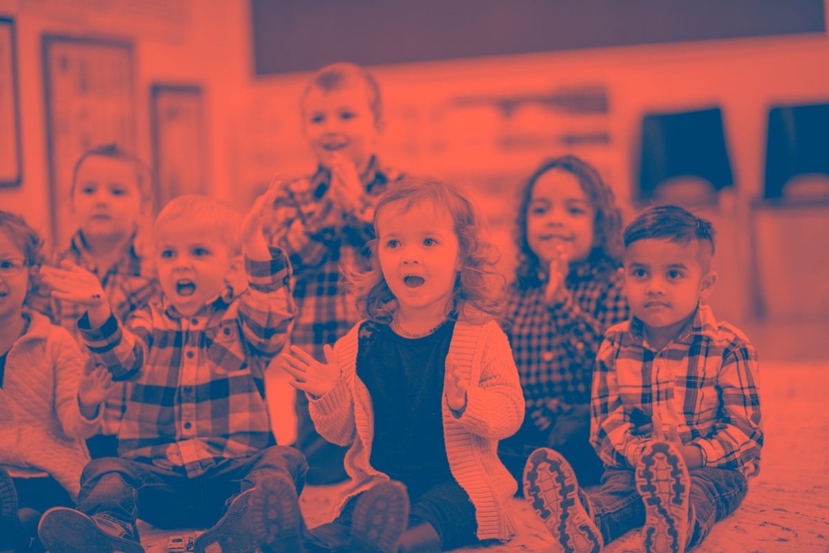 A group of young, early years aged children in a school classroom